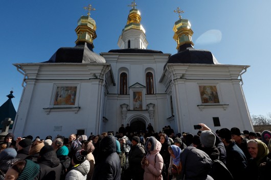 Věřící Ukrajinské pravoslavné církve, která čelí obvinění z napojení na Moskvu, se modlí před vchodem do kostela v areálu kláštera Pečerská lávra v Kyjevě a blokují tím vstup do budovy. ,  Autor: Valentyn Ogirenko,  Zdroj: Reuters
