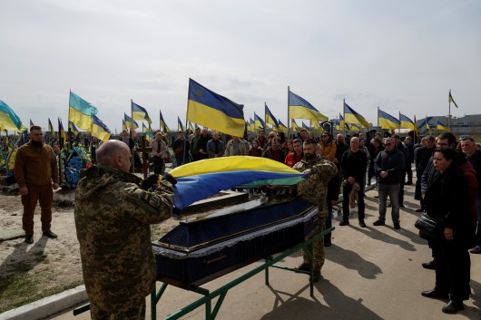 Ukrajinští vojáci drží státní vlajku nad rakví s mrtvým vojákem,  Autor: Valentyn Ogirenko,  Zdroj: Reuters