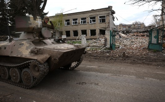Ukrajinští vojáci projíždějí kolem zničené školní budovy na cestě k frontové linii v okolí měst Bachmut a Časiv Jar,  Autor: Kai Pfaffenbach,  Zdroj: Reuters