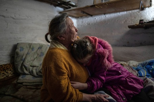 Desetiletá Chrystyna se ukrývá se svou babičkou Ljubov během ostřelování ukrajinské vesnice Bohoyavlenka,  Autor: Evgeniy Maloletka,  Zdroj: ČTK/AP